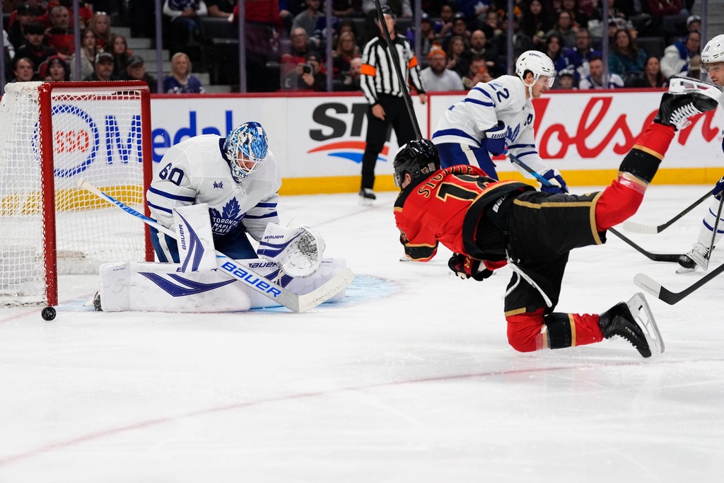 Ottawa Senators' Tim Stutzle (18) falls as he shoots againstn Toronto Maple Leafs goaltender Joseph Woll (60) during second-period NHL hockey game action in Ottawa, Ontario, Saturday, March 21, 2026. (Justin Tang/The Canadian Press via AP)