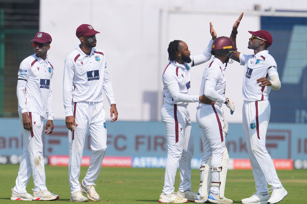 West Indies' Jomel Warrican, center, celebrates the dismissal of India's KL Rahul with teammates on the first day of the second cricket test match between India and West Indies at the Arun Jaitley Stadium in New Delhi, India, Friday, Oct.10, 2025. (AP Photo/Manish Swarup)