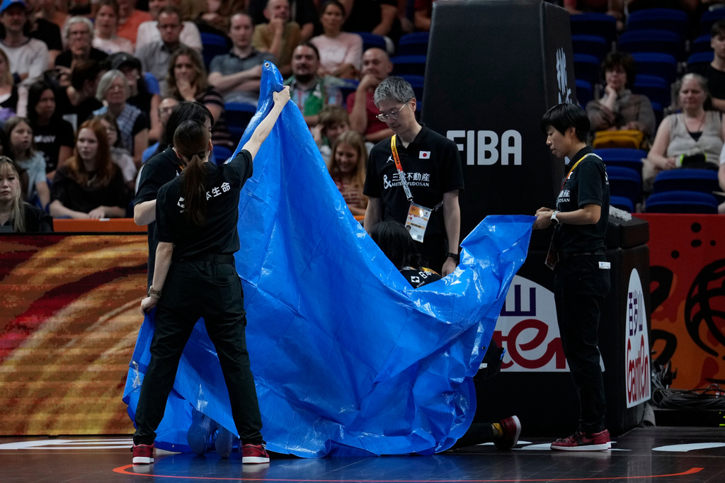 Japan's Saki Hayashi is treated behind a screen after an injury during the Women's Basketball World Cup qualification playoff between Hungary and Japan in Berlin, Tuesday Sept. 8, 2026. (AP Photo/Ebrahim Noroozi)