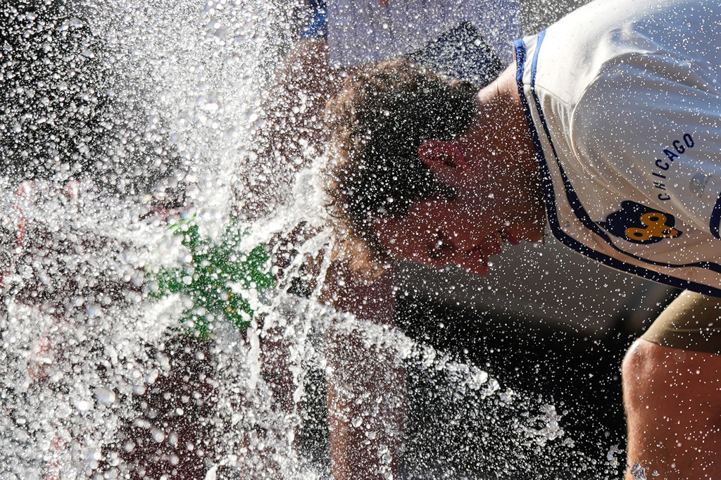 FILE - A person cools off in front of a Chicago Fire Department during a hot weather day in Chicago, June 30, 2026. (AP Photo/Nam Y. Huh, File)