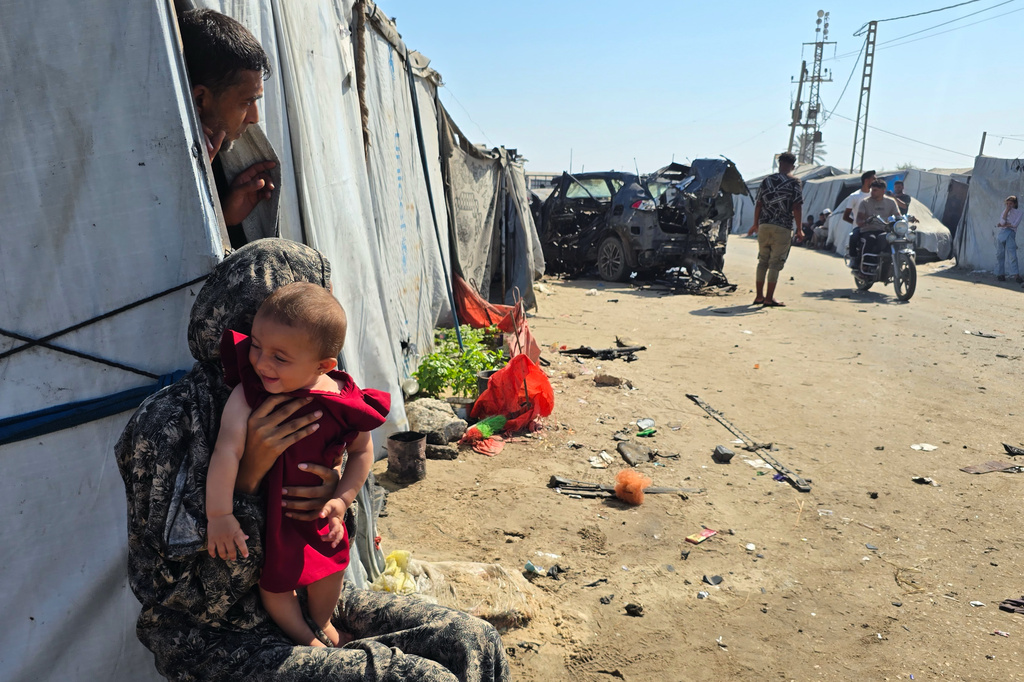Palestinians look at a destroyed car following an Israeli military strike in Khan Younis, southern Gaza Strip, Monday, July 6, 2026, that, according to hospital officials, killed at least one person. (AP Photo/Mohammad Jahjouh)