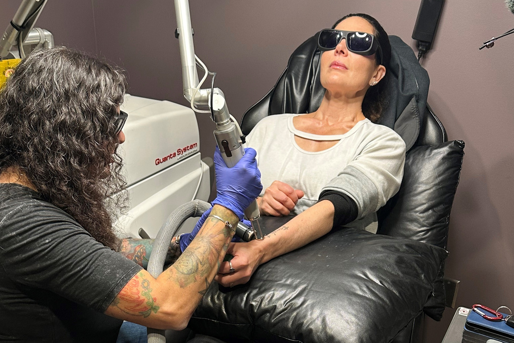 Tracy Herrmann has one of her tattoos removed by Chroma Tattoo Studio Laser Tattoo Removal owner Jaime Howard on Nov. 19, 2025, in West Bloomfield, Mich. (AP Photo/Corey Williams)