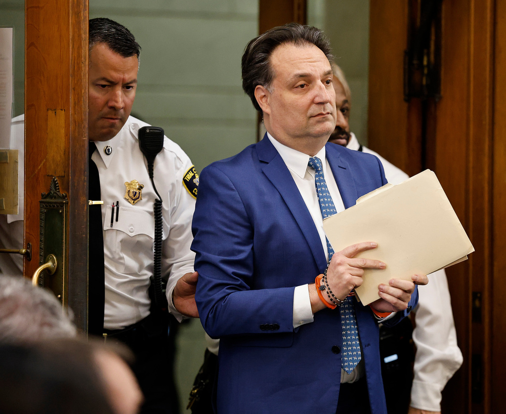 Brian Walshe enter the courtroom clutching papers and a rosary. Opening statements in the Brian Walshe murder trial in Norfolk Superior Court, Dedham, Mass., Monday, Dec. 1, 2025 (Greg Derr/The Patriot Ledger via AP, Pool)