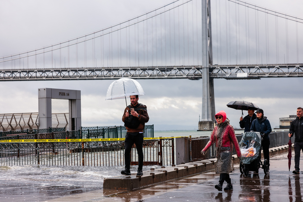People shield themselves from the rain Saturday, Jan. 3, 2026, in San Francisco. (Yalonda M. James/San Francisco Chronicle via AP)