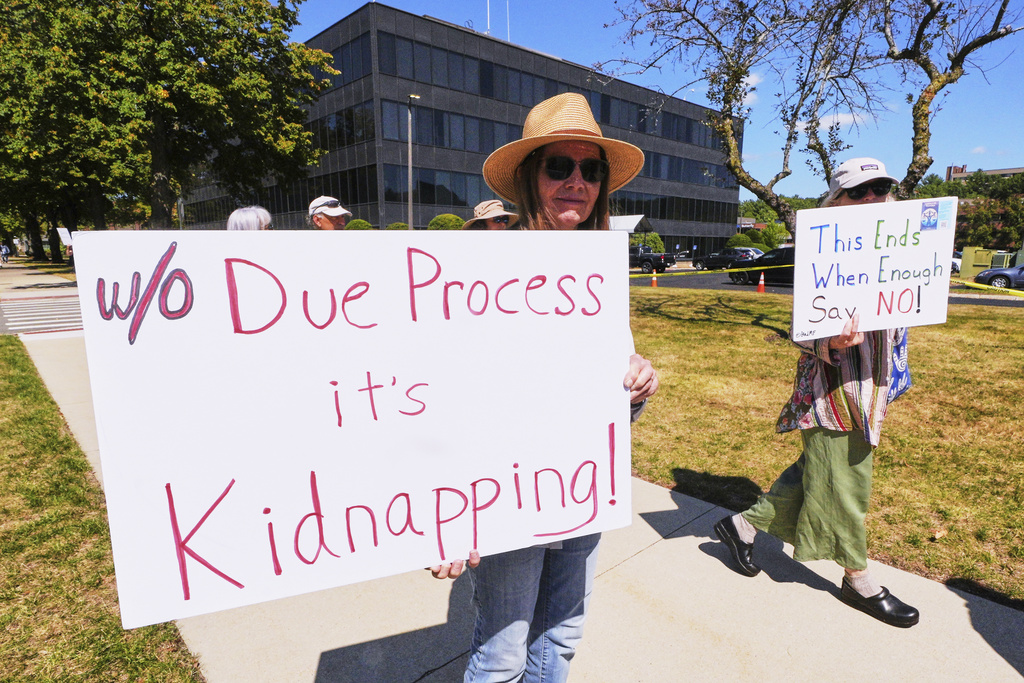 Protesters picket outside the U.S. Immigration and Customs Enforcement regional field office, Thursday, Sept. 11, 2025, in Burlington, Mass. (AP Photo/Charles Krupa)