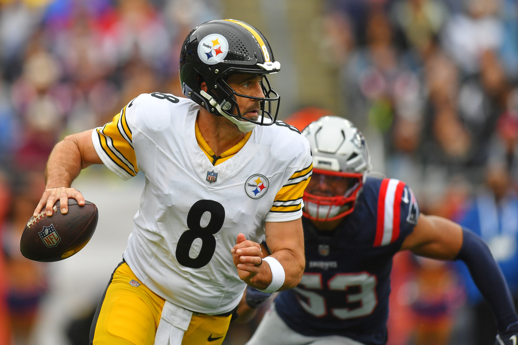 Pittsburgh Steelers' Aaron Rodgers (8) looks to pass as New England Patriots' Christian Elliss (53) pressures him during the first half of an NFL football game, Sunday, Sept. 20, 2026, in Foxboro, Mass. (AP Photo/Steven Senne)