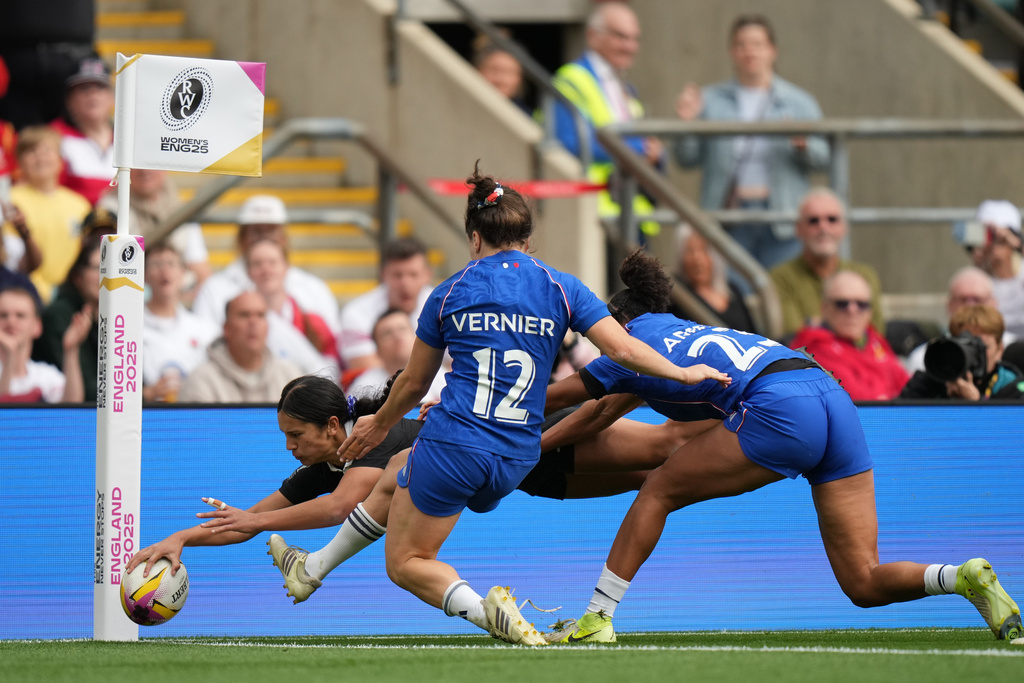 New Zealand's Braxton Sorensen-McGee, left, scores a try past Gaby Vernier of France, center and Kelly Arbey of France, right, during the Women's Rugby World Cup bronze match between New Zealand and France at the Allianz Stadium, Twickenham, London, Saturday, Sept. 27, 2025. (AP Photo/Alastair Grant)