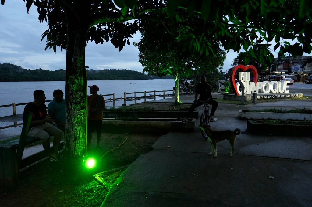 Residents chat at dusk on the banks of the Oiapoque River, in Oiapoque, Amapa state, Brazil, Monday, March 9, 2026. (AP Photo/Eraldo Peres)