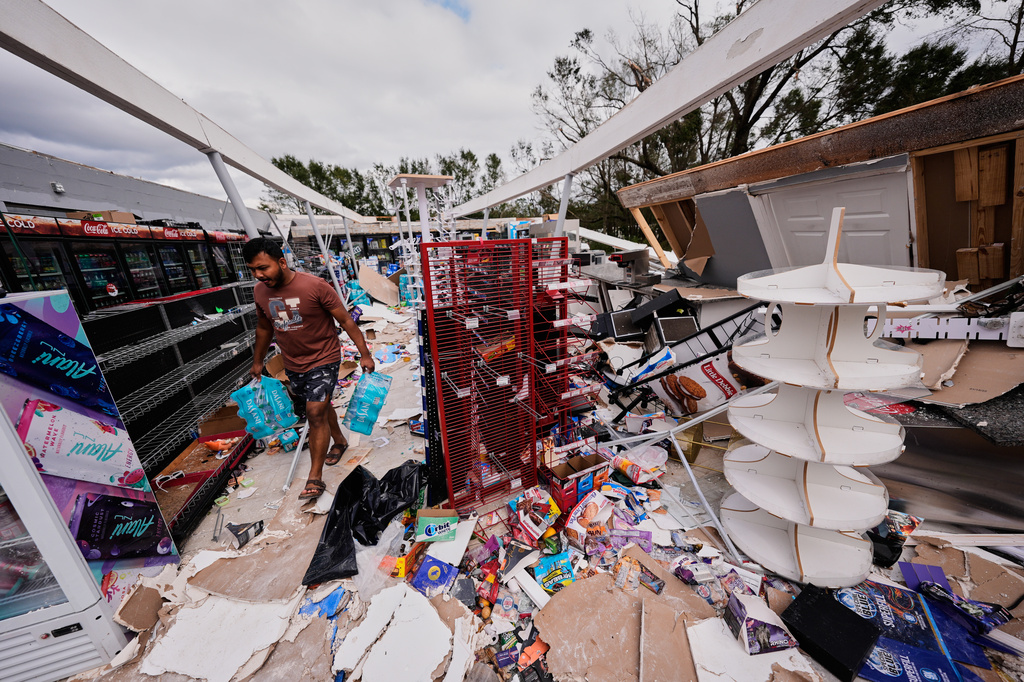 Islam Mahfuz salvages contents of their destroyed mini mart in the aftermath of Hurricane Isaias in Milton, Fla., Saturday, Oct. 10, 2026. (AP Photo/Gerald Herbert)