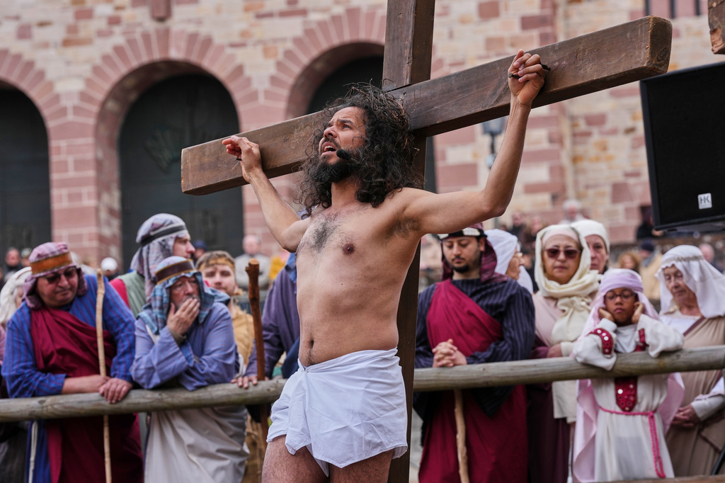 An amateur actor performing as Jesus is fixed on a cross during the traditional Good Friday procession organised by the Italian community in Bensheim, Germany, Friday, April 3, 2026. (AP Photo/Michael Probst)