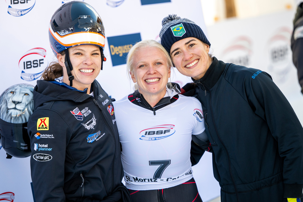 From left, second-placed Kelly Curtis of the U.S., winner Kim Meylemans of Belgium and third placed Nicole Rocha Silveira of Brazil react on the podium of the Women's Skeleton World Cup in St. Moritz, Switzerland, Friday, Jan. 9, 2026. (Mayk Wendt/Keystone via AP)