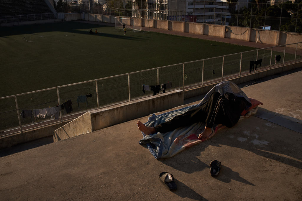 A Palestinian from Gaza who had a permit to work in Israel before the Oct. 7, 2023, Hamas attack sleeps in the grandstands of the municipal stadium, where some Palestinians stranded in the West Bank have taken shelter, in the West Bank city of Nablus, Thursday, May 7, 2026. (AP Photo/Leo Correa)