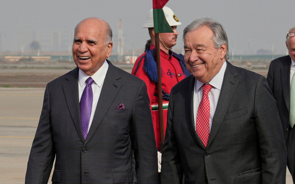 Iraqi Foreign Minister Fouad Hussein, left, greets United Nations Secretary-General Antonio Guterres at Baghdad airport, Iraq, Saturday, Dec. 13, 2025. (AP Photo/Hadi Mizban)