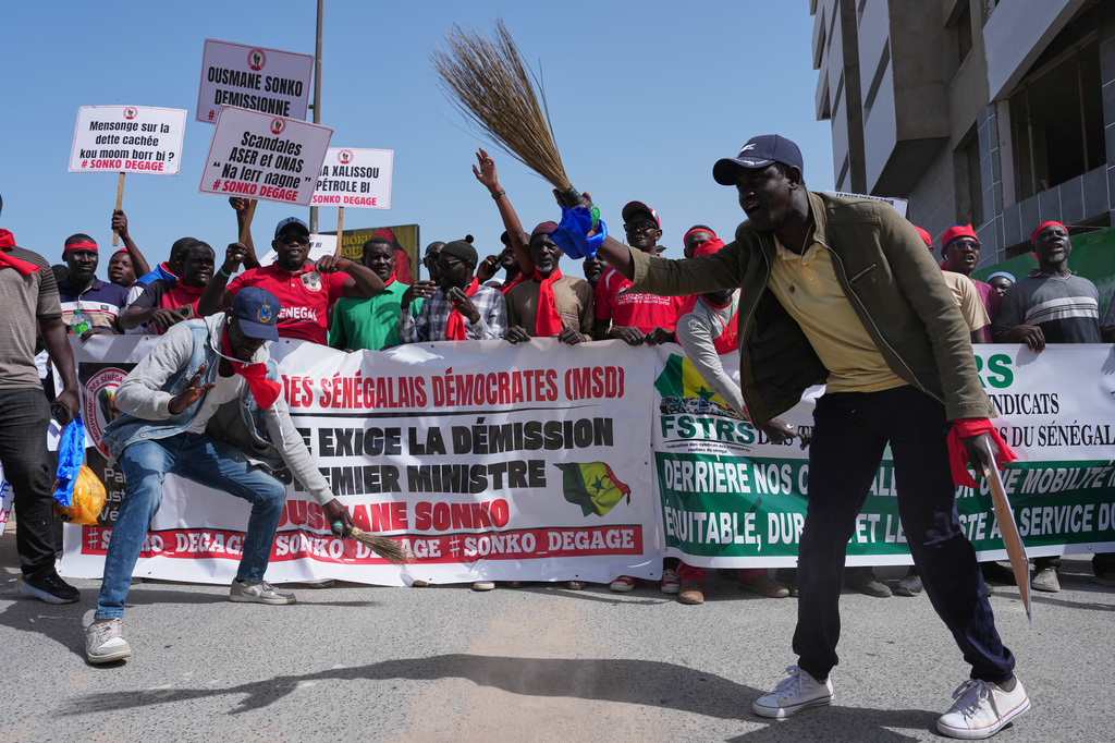 Workers hold placards and banners as they assemble to march, demanding that the government honor its commitments and address their concerns, in Dakar, Senegal, Wednesday, April 8, 2026. (AP Photo/Misper Apawu)