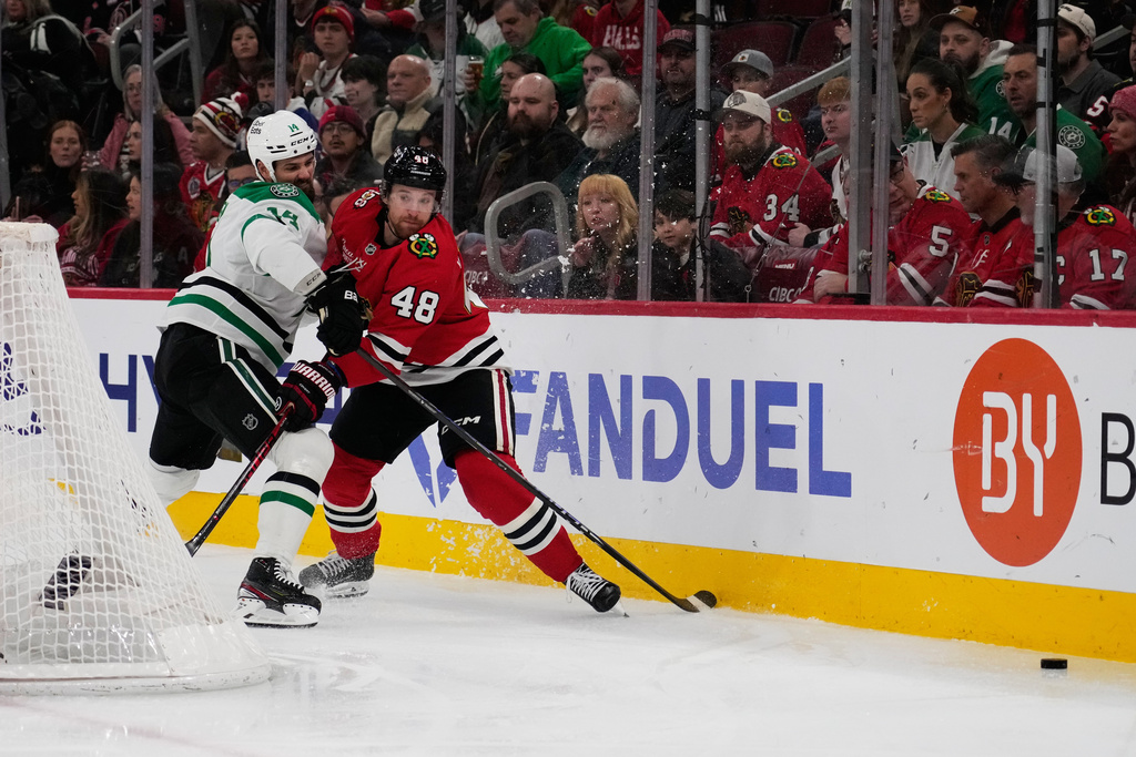 Dallas Stars left wing Jamie Benn, left, and Chicago Blackhawks defenseman Matt Grzelcyk battle for the puck during the first period of an NHL hockey game in Chicago, Thursday, Jan. 1, 2026. (AP Photo/Nam Y. Huh)