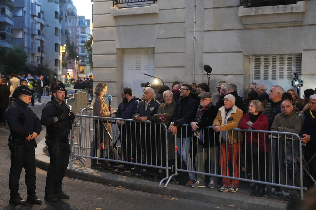 People gather outside former French President Nicolas Sarkozy's home, Tuesday, Oct. 21, 2025 in Paris. Former French President Nicolas Sarkozy heads to prison to serve time for a criminal conspiracy to finance his 2007 election campaign with funds from Libya. (AP Photo/Thibault Camus)