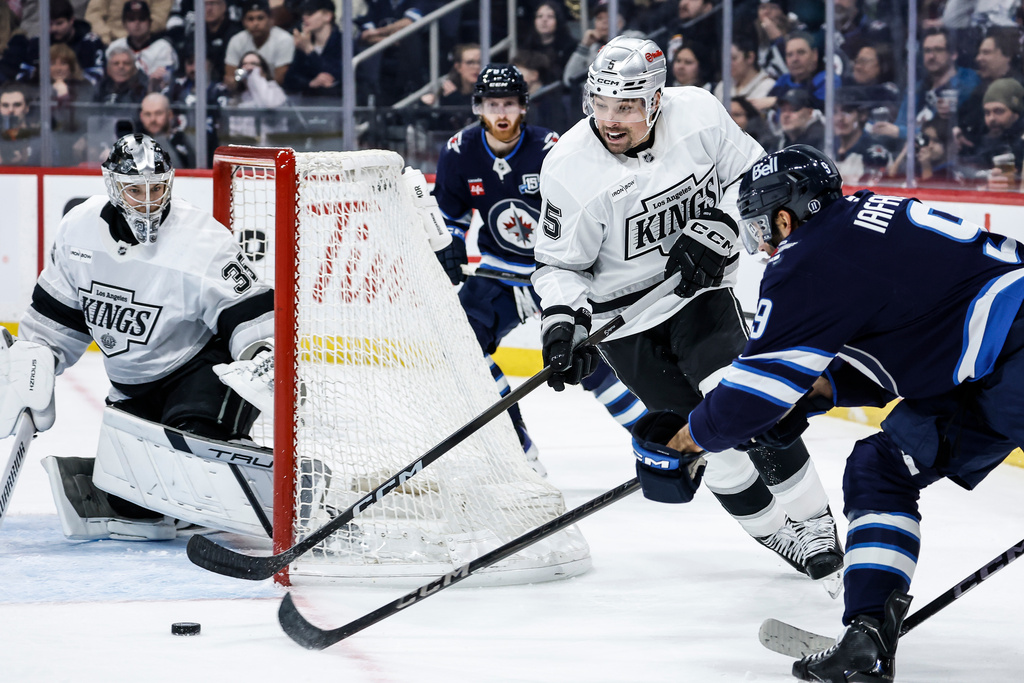 Los Angeles Kings' Cody Ceci (5) protects the puck from Winnipeg Jets' Alex Iafallo (9) during the second period of an NHL game in Winnipeg, Friday, January 9, 2026. (John Woods/The Canadian Press via AP)