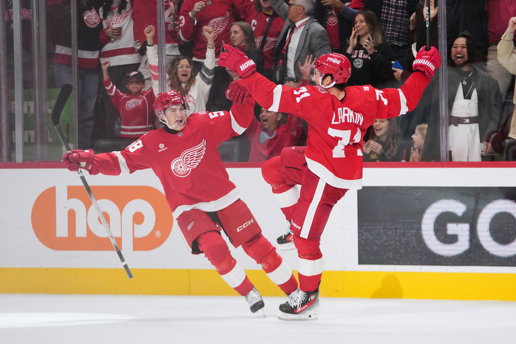 Detroit Red Wings center Dylan Larkin (71) celebrates his goal with Emmitt Finnie (58) against the Tampa Bay Lightning during overtime in an NHL hockey game Friday, Oct. 17, 2025, in Detroit. (AP Photo/Paul Sancya)