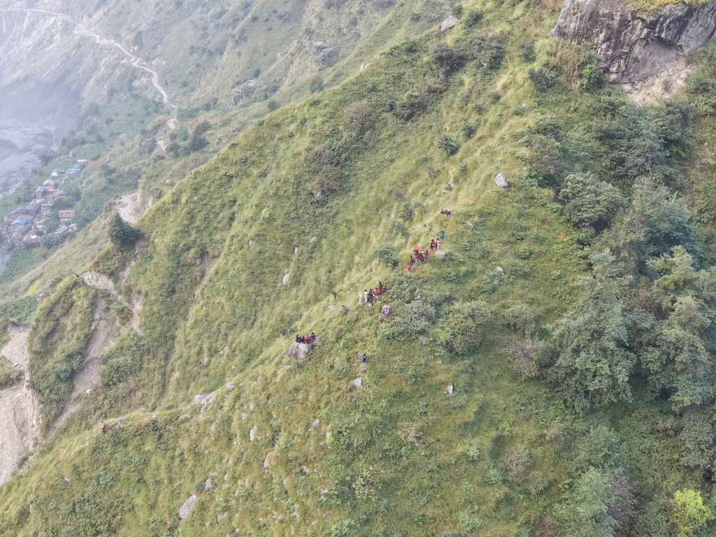 In this photo provided by the National Trust for Nature Conservation-Manaslu Conservation Area Project (NTNC-MCAP), survivors sit on higher ground in Gorkha district after flooding in the Budhi Gandaki River in north central Nepal, Sunday, Oct. 11, 2026. (NTNC-MCAP via AP)