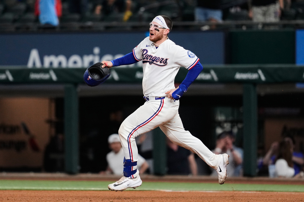 Texas Rangers' Danny Jansen celebrates his run-scoring single as he rounds first in the ninth inning of a baseball game against the Arizona Diamondbacks Wednesday, May 13, 2026, in Arlington, Texas. (AP Photo/Tony Gutierrez)