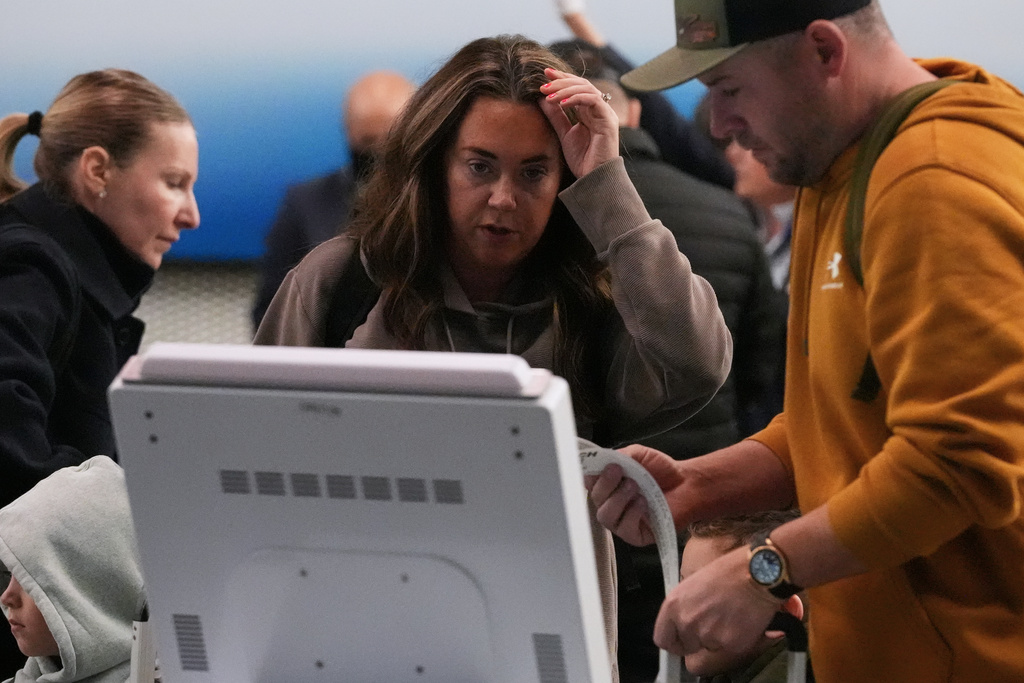 Travelers check their tickets at O'Hare International Airport in Chicago, Wednesday, Nov. 12, 2025. (AP Photo/Nam Y. Huh)