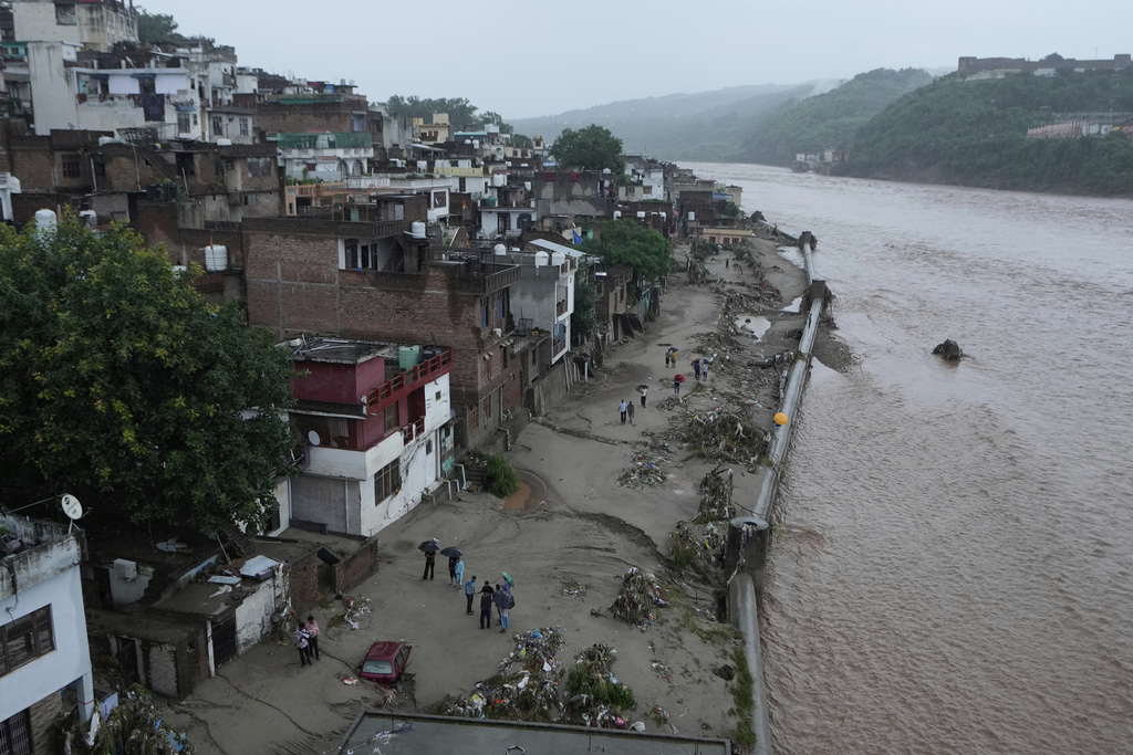 Residents check the damage caused to their house by flash floods at banks of Tawi river in Jammu, India, Wednesday, Aug. 27, 2025. (AP Photo/Channi Anand)