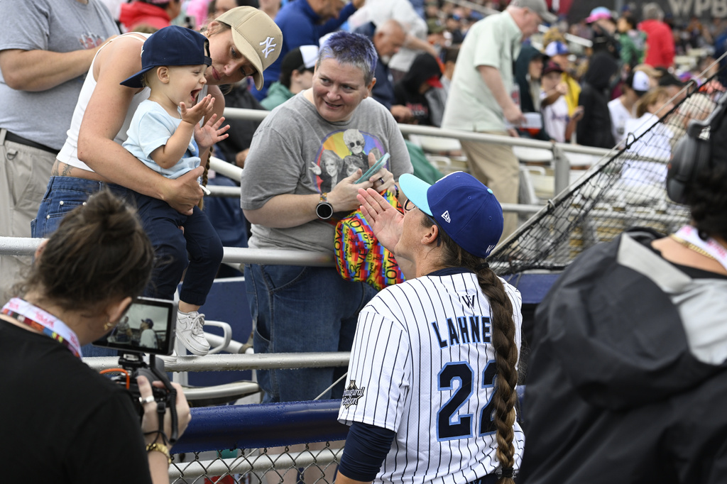 A young fan blows a kiss to New York Heights' Kylee Lahners (22) before the inaugural Women's Professional Baseball League game against the Los Angeles Queens, Saturday, Aug. 1, 2026, in Springfield, Ill. (AP Photo/Lexie Knight)