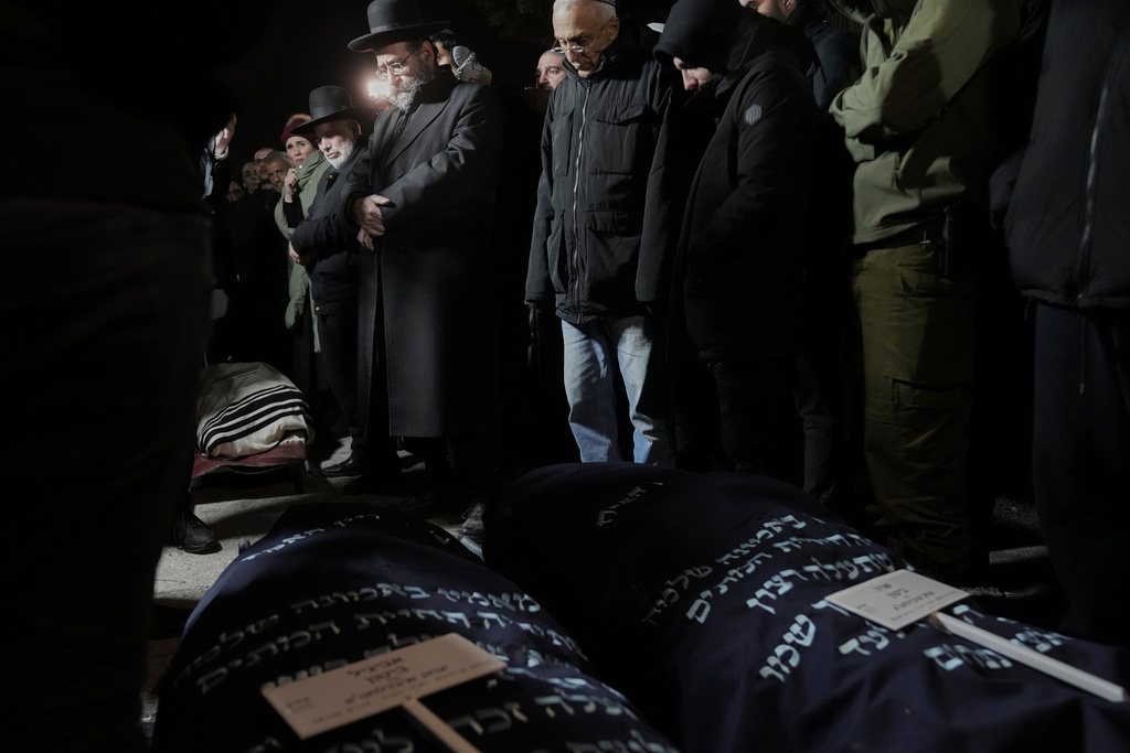 FILE - Mourners attend the funeral of Yaakov Biton, 16, and his two sisters, Avigail, 15, and Sarah, 13, who were killed in an Iranian missile attack, at the cemetery in Mount of Olives in Jerusalem, Monday, March 2, 2026. (AP Photo/Mahmoud Illean, File)