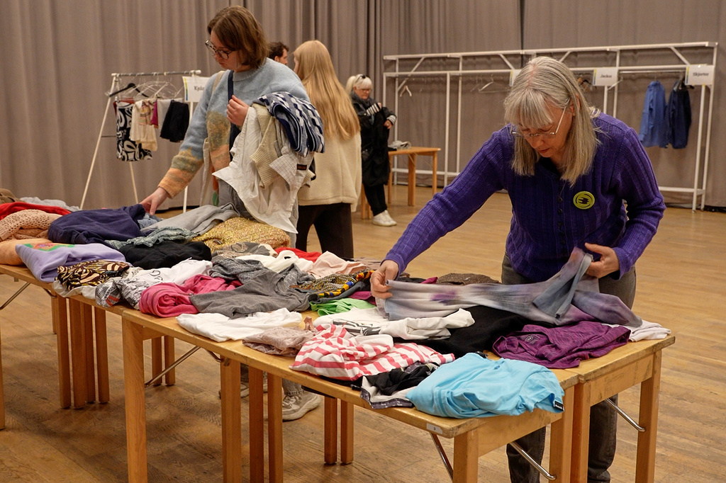 Meg Goldmann, right, a volunteer with the Swedish Society for Nature Conservation, folds secondhand clothes at a clothing swap event in Stockholm, Sweden, Saturday, April 19. 2026. (AP Photo/Chisato Tanaka)