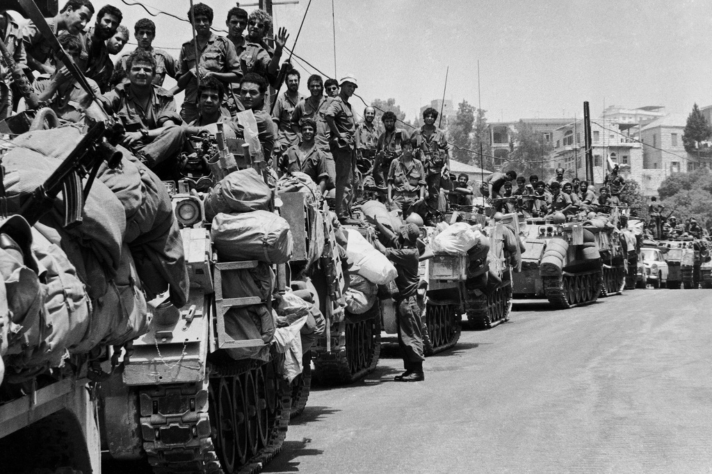 FILE.- A long line of Israeli armoured personnel carriers and their crews wait on a street on the outskirts of Beirut, on July 27, 1982, for the order to proceed into the capital. (AP Photo/Max Nash,File)