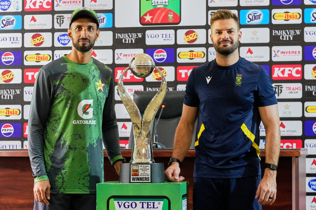 Pakistan's test team skipper Shan Masood, left, and his South Africa's counterpart Aiden Markram pose for photograph with test series trophy, in Lahore, Pakistan, Saturday, Oct. 11, 2025. (AP Photo/K.M. Chaudary)