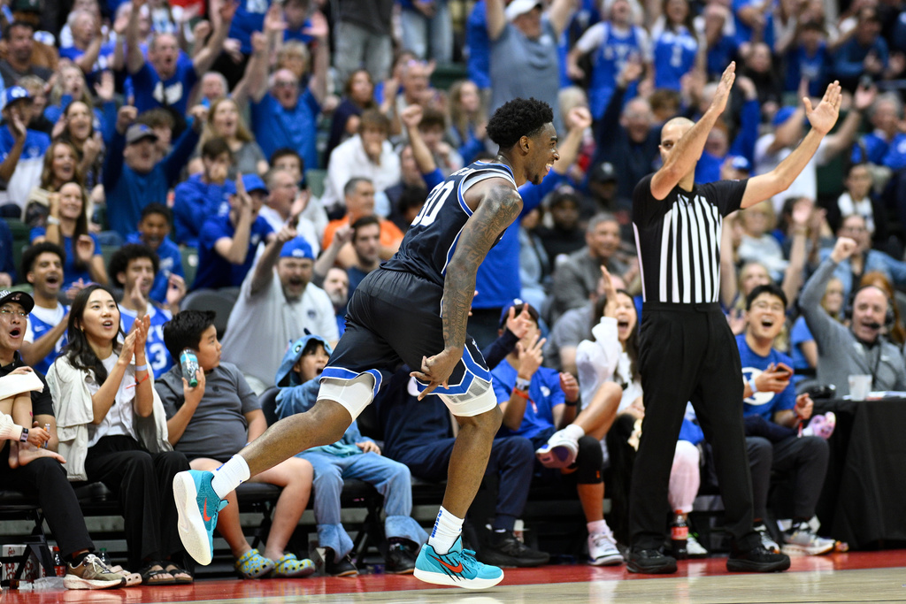 BYU guard Kennard Davis Jr., center, reacts after scoring a 3-point basket during the second half of an NCAA college basketball game against Miami, Thursday, Nov. 27, 2025, in Kissimmee, Fla. (AP Photo/Phelan M. Ebenhack)