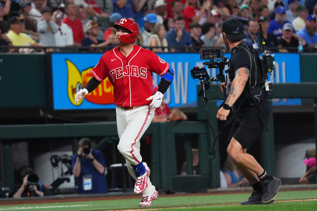 Texas Rangers' Kyle Higashioka, left, runs the bases after hitting a home run during the sixth inning of a baseball game against the Cleveland Guardians, Friday, June 5, 2026, in Arlington, Texas. (AP Photo/LM Otero)