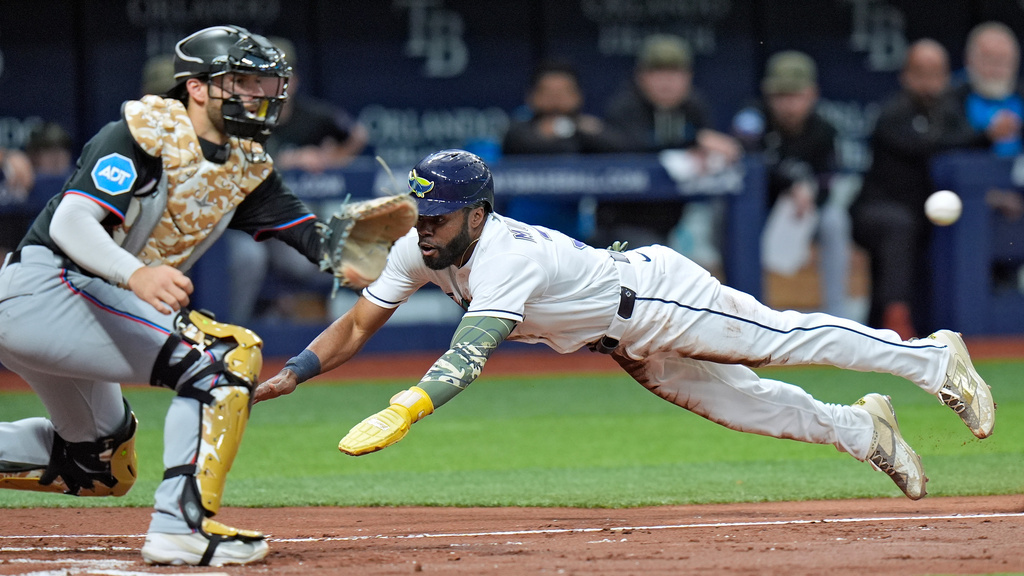 Tampa Bay Rays' Cedric Mullins, right, scores ahead of the throw to Miami Marlins catcher Joe Mack on a fielder's choice by Taylor Walls during the second inning of a baseball game Friday, May 15, 2026, in St. Petersburg, Fla. (AP Photo/Chris O'Meara)