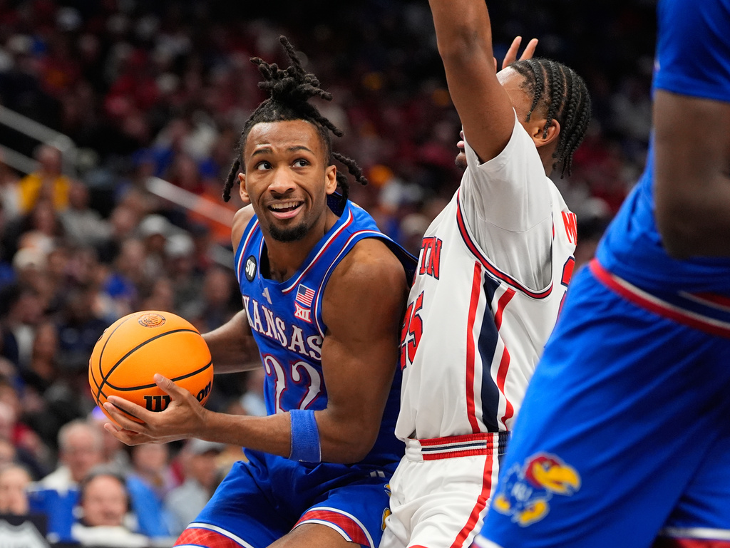 Kansas' Darryn Peterson (22) looks past Houston's Mercy Miller during the first half of an NCAA college basketball game in the semifinal round of the Big 12 Conference tournament Friday, March 13, 2026, in Kansas City, Mo. (AP Photo/Charlie Riedel)