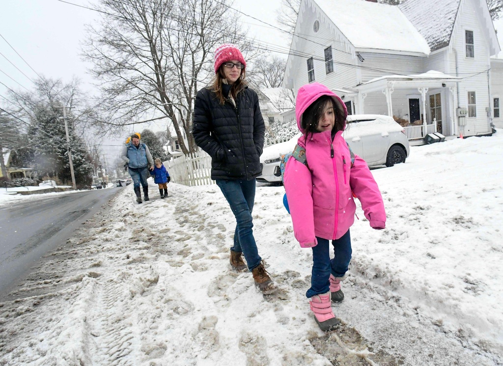 Rebecca Soubbel of Brattleboro, Vt., walks her daughter, Eleanor Raymond, 5, a kindergartener, to Green Street Elementary School in Brattleboro, after a two-hour delay from a wintry mess on Wednesday, Jan. 7, 2026. (Kristopher Radder /The Brattleboro Reformer via AP)