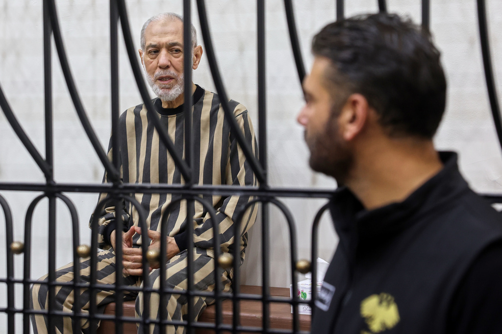 Syria's former grand mufti under ousted President Bashar Assad, Ahmad Badreddine Hassoun, sits in the defendants' cage before a court sentences him to life in prison at the Palace of Justice in Damascus, Syria, Monday, Aug. 24, 2026. (AP Photo/Ghaith Alsayed)