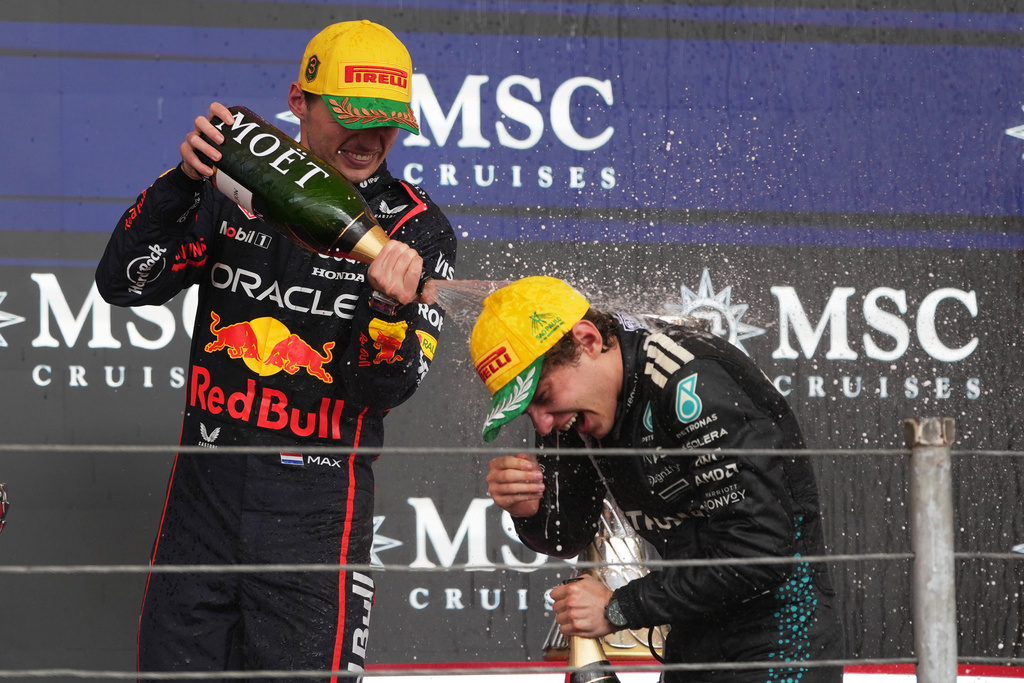 Red Bull driver Max Verstappen of the Netherlands, left, sprays champagne on Mercedes driver Kimi Antonelli of Italy at the podium during the Brazilian Formula One Grand Prix at the Interlagos race track in Sao Paulo, Sunday, Nov. 9, 2025. (AP Photo/Andre Penner)