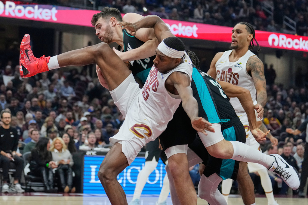 Cleveland Cavaliers forward Nae'Qwan Tomlin (35) fouls Portland Trail Blazers center Donovan Clingan (23) in the first half of an NBA basketball game Wednesday, Dec. 3, 2025, in Cleveland. (AP Photo/Sue Ogrocki)