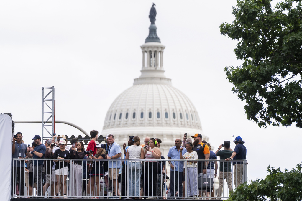 Spectators watch from an overpass near the U.S. Capitol as race car drivers take practice runs along Pennsylvania Avenue prior to Sunday's Freedom 250 Grand Prix auto race in Washington, Saturday, Aug. 22, 2026. (AP Photo/Manuel Balce Ceneta)
