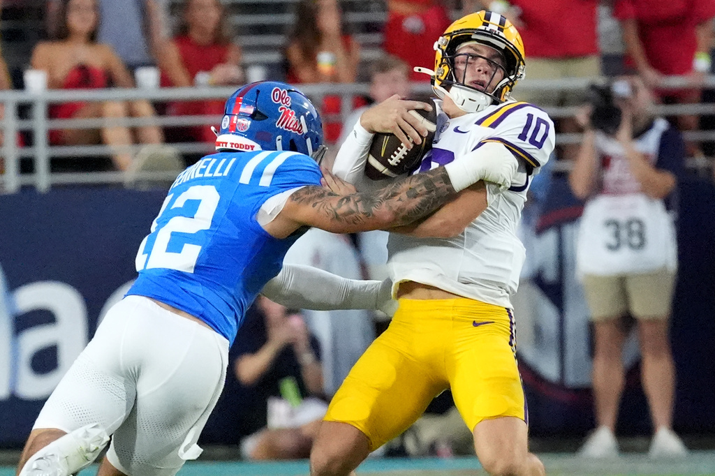 LSU quarterback Sam Leavitt (10) attempts to fight off a arm tackle by Mississippi linebacker Luke Ferrelli (12) during the first half of an NCAA college football game in Oxford, Miss., Saturday, Sept. 19, 2026. (AP Photo/Rogelio V. Solis)