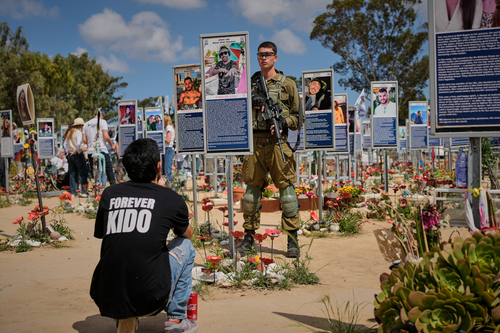Soldiers and civilians mark Israel's annual Memorial Day at the site of the Nova music festival where hundreds of revelers were killed and abducted in the Oct. 7, 2023 Hamas attack near Kibbutz Reim in southern Israel Tuesday, April 21, 2026. (AP Photo/Ohad Zwigenberg)