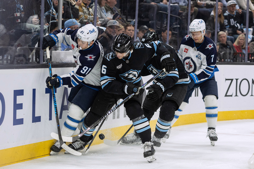 Winnipeg Jets center Cole Perfetti (91) fights for the puck against Utah Mammoth defenseman John Marino (6) during the second period of an NHL hockey game Sunday, Dec. 21, 2025, in Salt Lake City. (AP Photo/Melissa Majchrzak)