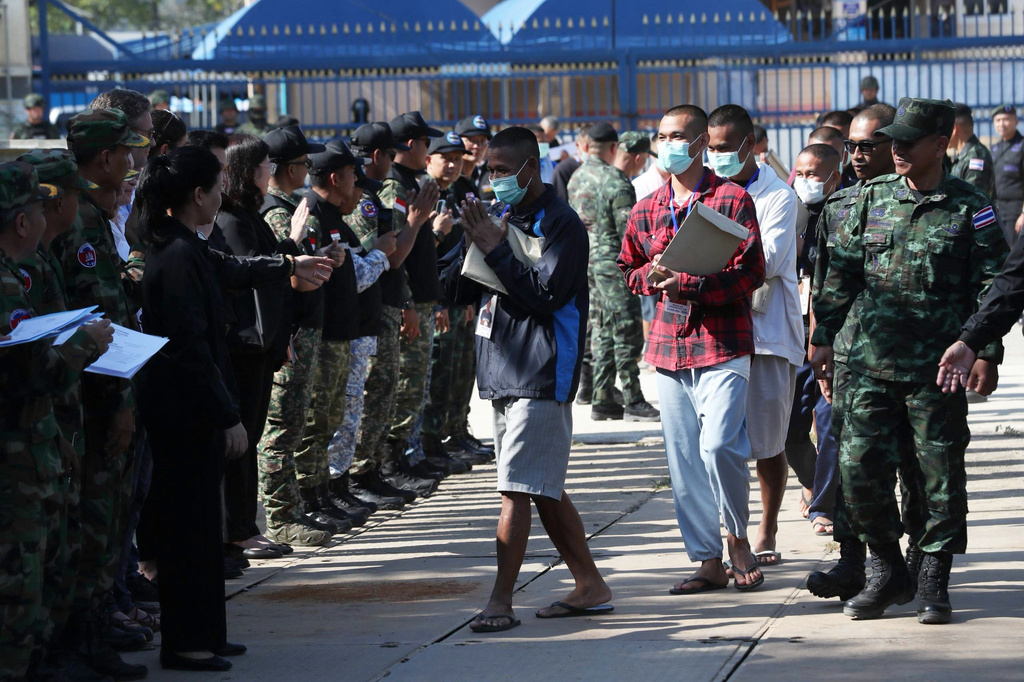 In this photo released by Agence Kampuchea Press (AKP), Cambodian soldiers, center, arrive after being captured and held by the Thai army, at Prum border gate, in Pailin province, Cambodia, Wednesday, Dec. 31, 2025. (AKP via AP)