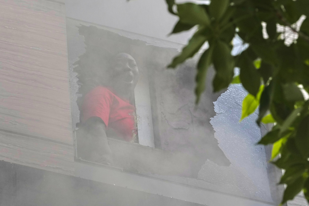 A foreign national woman shouts for help from a hotel window as fire engulfs the building in New Delhi, India, Wednesday, June 3, 2026. (AP Photo/Manish Swarup)