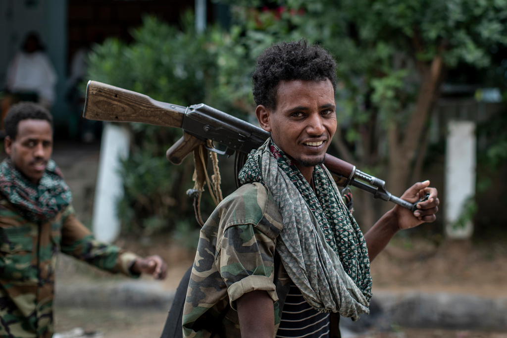 FILE - Fighters loyal to the Tigray People's Liberation Front (TPLF) walk along a street in the town of Hawzen, then controlled by the group, in the Tigray region of northern Ethiopia, May 7, 2021. (AP Photo/Ben Curtis, File)