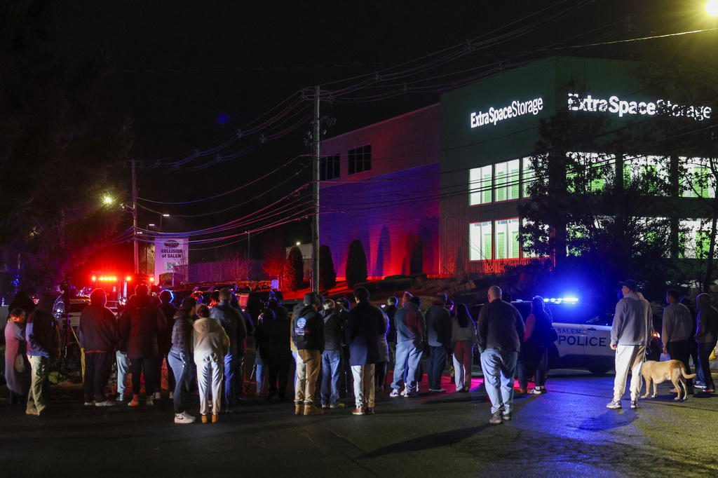 People gather outside a storage facility where a suspect in the shooting at Brown University was found dead, Thursday, Dec. 18, 2025, in Salem, N.H. (AP Photo/Reba Saldanha)