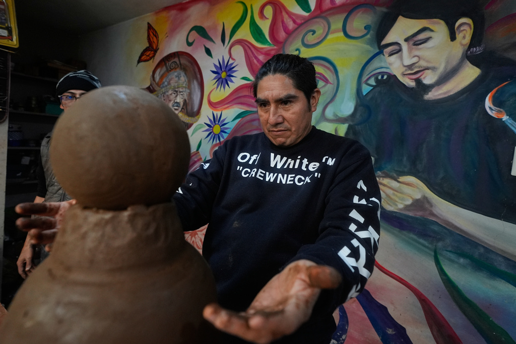 Mexican craftsman Cecilio Sanchez works on a clay piece at his atelier in Metepec, Mexico, Thursday, Oct. 9, 2025. (AP Photo/Fernando Llano)