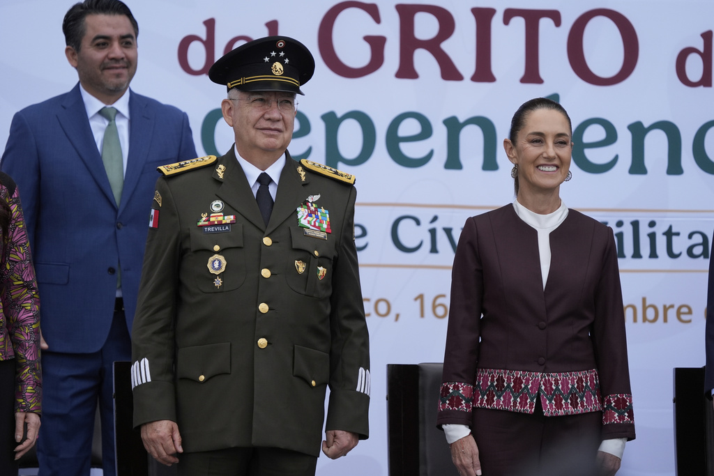 Defense Minister Gen. Ricardo Trevilla Trejo, left, and President Claudia Sheinbaum look out at troops before the start of the annual Independence Day parade in the capital's main square, the Zocalo, in Mexico City, Tuesday, Sept. 16, 2025. (AP Photo/Fernando Llano)