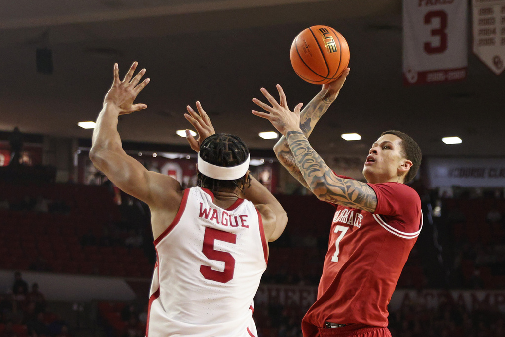 Arkansas Razorbacks forward Trevon Brazile (7) looks to shoot over Oklahoma Sooners forward Mohamed Wague (5) during the first half of an NCAA college basketball game Tuesday, Jan. 27, 2026, in Norman, Okla. (AP Photo/Nate Billings)